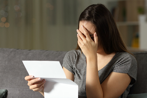 Sad woman reading a letter